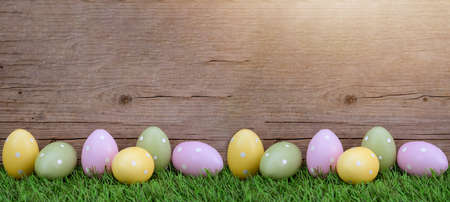 Easter background greeting card - Many pastel painted dotted Easter eggs on fresh green meadow...