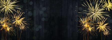 HAPPY NEW YEAR 2022 - Festive silvester firework background panorama greeting card banner long - Golden fireworks on dark black wood wall textureの写真素材