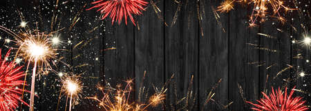 New Year's Eve, Silvester background panorama long - Firework on rustic black wooden texture with...