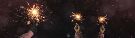Silvester / Party / New Year / Celebration / wedding background banner panorama - Happy girl and woman holding sparkling sparklers in her hands at dark night, New Year's Eveの写真素材