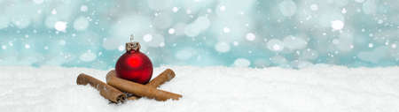 Red baubles and cinnamon sticks on snow snowflakes - Christmas winter background banner long