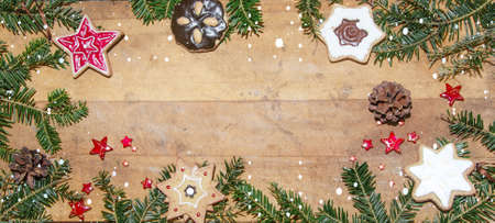 Frame of cookies and pine branches on rustic wooden table - christmas background panorama banner...