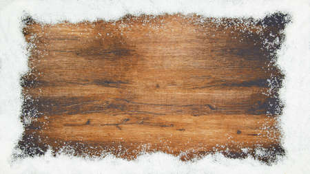 winter / Advent / christmas Background template - Frame made of snow with snowflakes on brown wooden texture, top view with space for textの写真素材