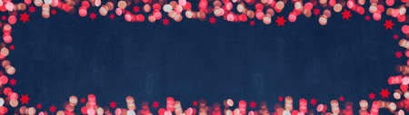 Christmas advent background banner panorama template - Top view of frame made of bokeh pink lights and stars isolated on blue texture, with space for textの写真素材