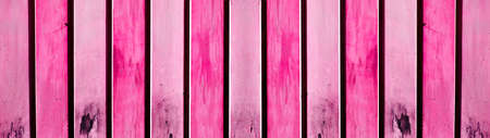 Old abstract weathered aged grunge brightly colorful pink painted colored garage door made of sheet steel boards texture background banner panoramaの写真素材