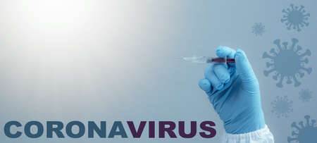 CORONAVIRUS COVID-19 / CORONA VACCINATION - Close-up from doctor holds syringe and Corona vaccine in his hands, isolated on blue background with virus symbolの写真素材