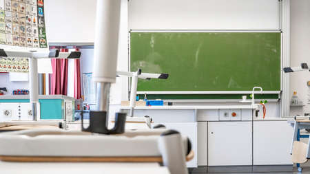 Empty physics biology chemistry room with high chairs and virus symbols on the blackboardの写真素材