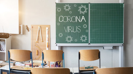 CORONAVIRUS - School closed - Empty classroom with high chairs and empty green blackboard / chalkboardの写真素材