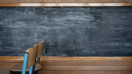 Empty blackboard in a classroom in school with wooden chairs and tableの写真素材