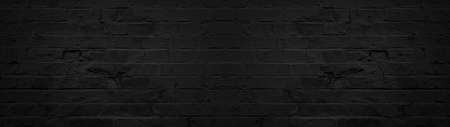 Dark black anthracite damaged rustic brick wall texture banner panorama patternの写真素材