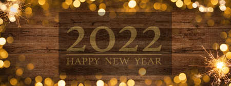 Frame of lights bokeh golden flares and sparkler isolated on rustic brown wooden texture - Holiday New Year's Eve Silvester New Year Party festive background banner greeting card ..の写真素材