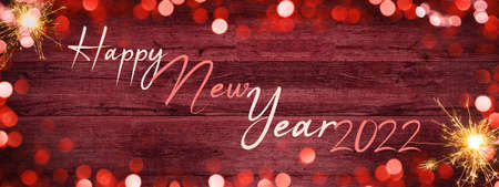 Frame of lights bokeh golden flares and sparkler isolated on rustic red wooden texture - Holiday New Year's Eve Silvester New Year Party festive background banner greeting cardの写真素材