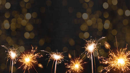 Silvester 2022 New Year New Year's Eve Party background - sparklers fireworks and bokeh light on black night texture, with space for text.の写真素材