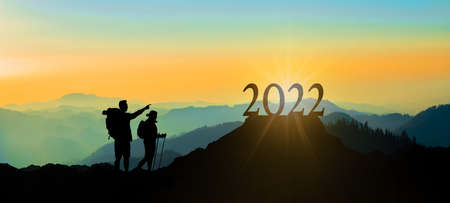 NEW YEAR 2022 - Blue yellow black landscape hiking background banner panorama illustration - Breathtaking view with black silhouette of mountains in the black forest, hills, forest and young hikersの写真素材