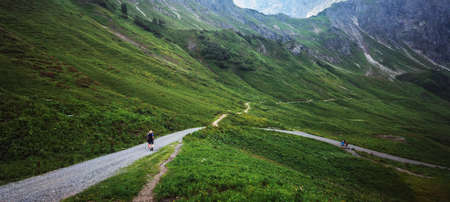 Kleinwalsertal mountains landscape panorama background - Mountain panorama in summer with fresh green meadow and lots of hiking hikersの写真素材