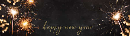 HAPPY NEW YEAR 2023 background banner panorama greeting card, celebration holiday Silvester Party - Festive sparkling sparklers, bokeh lights and fireworks, on black dark night textureの写真素材