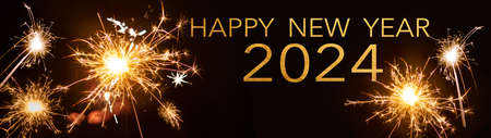 Silvester / Happy New year 2024, New Year's Eve background banner panorama greeting card - People hold sparkling sparkler in her hand at dark nightの写真素材