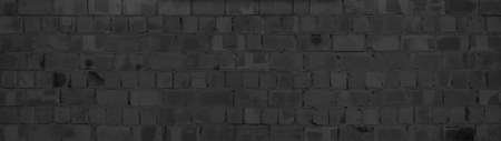 Black anthracite gray dark damaged rustic brick wall brickwork stonework masonry texture background banner panorama patternの写真素材
