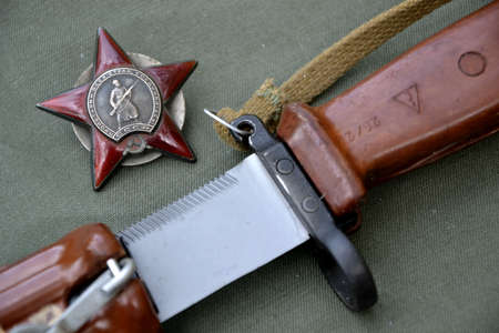 Russian soviet composition of the Afghanistan conflict era: Red Star award medal and bayonet dagger. Text on the medal says "proletarians of all countries, unite!"のeditorial素材
