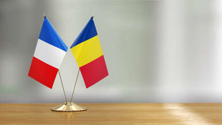 French and Romanian flag pair on a desk over defocused backgroundの写真素材