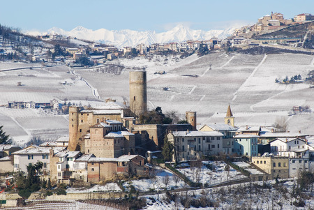 View of Langhe hills with snow and the village of Castiglion Falletto, Piedmont - Italy