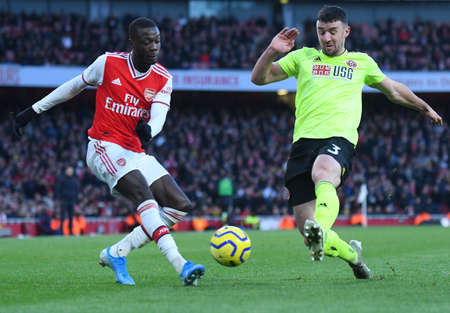 LONDON, ENGLAND - JANUARY 18, 2020: Nicolas Pepe of Arsenal and Enda Stevens of Sheffield pictured during the 2019/20 Premier League game between Arsenal FC and Sheffield United FC at Emirates Stadium.のeditorial素材
