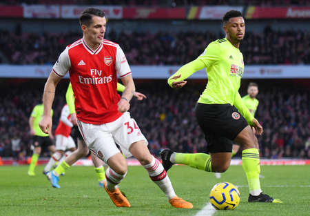 LONDON, ENGLAND - JANUARY 18, 2020: Granit Xhaka of Arsenal and Lys Mousset of Sheffield pictured during the 2019/20 Premier League game between Arsenal FC and Sheffield United FC at Emirates Stadium.のeditorial素材