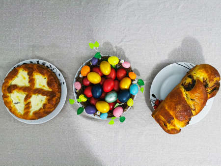 Image of easter traditional dinner dishes like coloured eggs, cheese cake and panettoneの写真素材