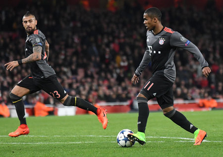 LONDON, ENGLAND - MARCH 7, 2017: Douglas Costa (L) of Bayern pictured in action during the second leg of the UEFA Champions League Round of 16 game between Arsenal FC and Bayern Munchen at Emirates Stadium. Copyright: Cosmin Iftode/Picstaffのeditorial素材