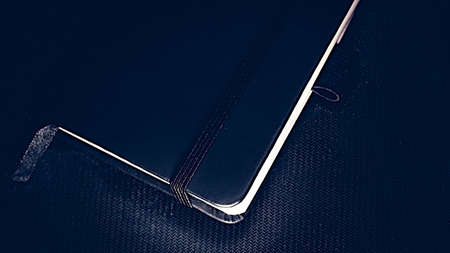 Notebook with black cover on black backgroundの写真素材