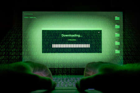 Hacker using laptop. Lots of digits on the computer screen.の写真素材