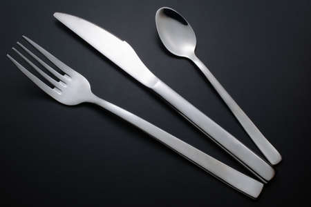 knife, fork and teaspoon on black backgroundの写真素材