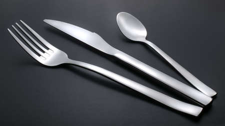 knife, fork and teaspoon on black backgroundの写真素材