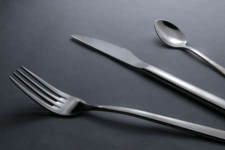 knife, fork and teaspoon on black backgroundの写真素材