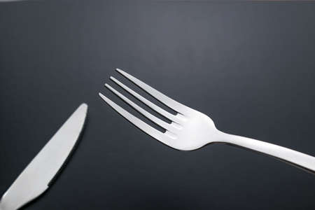 knife and fork on black backgroundの写真素材