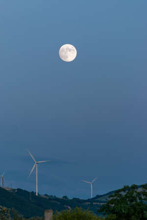 wind turbines at night on the hill in a full moon nightの写真素材