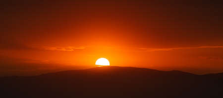 Beautiful sunset sky above clouds with dramatic light.の写真素材