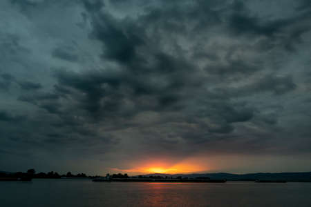 Dramatic stormy dark cloudy sky, natural photo backgroundの写真素材