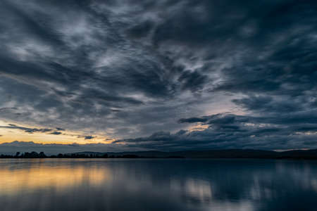 Dramatic stormy dark cloudy sky, natural photo backgroundの写真素材