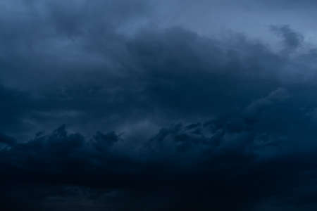 Dramatic stormy dark cloudy sky, natural photo backgroundの写真素材