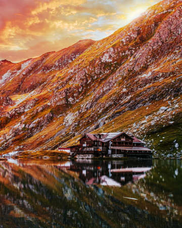BÃ¢lea Lake in the FÄgÄraÈ Mountains, Sibiu County. Reflection of the cottage in the water of the lake at sunset. Picture taken on August 30th, 2019.の写真素材