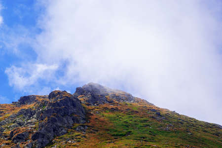 mountain peak covered by clouds and fogの写真素材