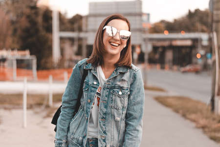 Fashionable girl laughing to camera while resting in summer dayの写真素材