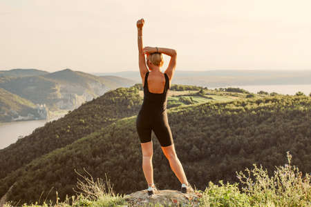 girl with blond and short hair at the top of the mountainの写真素材