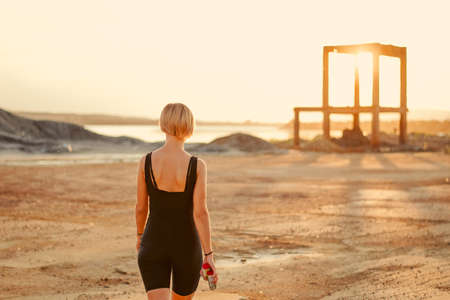A young girl stands with her back and takes pictures of the landscape.の写真素材