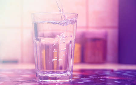 Glass of pure water on kitchen tableの写真素材