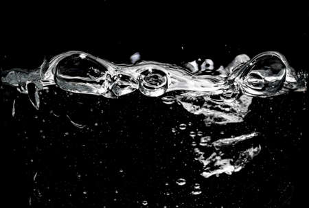 Clear water surface on a black with ripple and bubblesの写真素材