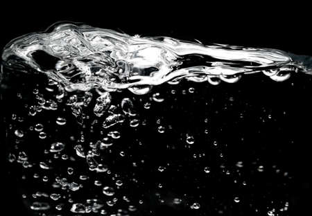 Clear water surface on a black with ripple and bubblesの写真素材