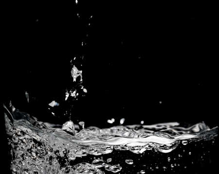 Clear water surface on a black with ripple and bubblesの写真素材