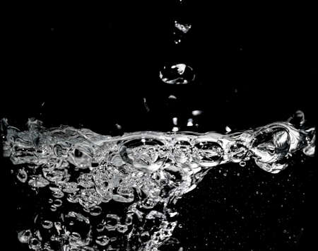Clear water surface on a black with ripple and bubblesの写真素材